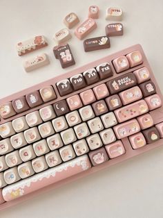 a pink computer keyboard with hello kitty stickers on it's backlit keys