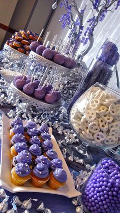 a table topped with lots of purple and white desserts