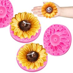 three sunflowers are in the shape of soap molds with one being held by a person's hand