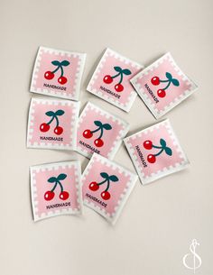 six stamps with cherries on them and the words handmade are placed in front of each other