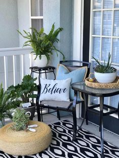 two chairs sitting on top of a black and white rug next to potted plants