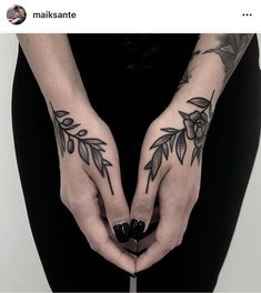 two hands with tattoos on them holding a knife in the shape of a flower and leaves