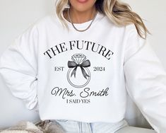 Did you recently get engaged?  This custom FUTURE MRS Gildan 18000 sweatshirt is the perfect way to show your excitement for your newly engaged status.  The addition of your future last name makes this sweater extra special.  Buy for yourself or make this an engagement gift, bridal shower gift, or gift for the newly engaged bride-to-be. PLEASE READ THROUGH ALL OF THE FOLLOWING INFORMATION.  IF YOU HAVE FURTHER QUESTIONS, WE ARE HAPPY TO HELP! Welcome to CuratedClothCo.!  Here you can find the pe Long Sleeve Cotton Sweatshirt For Anniversary, Newly Engaged Gift, Engagement Gifts Newly Engaged, Mrs Sweatshirt, Get Engaged, Screen Printing Techniques, Just Engaged, Personalized Bride, Future Mrs