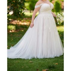 a woman in a wedding dress posing for the camera with her hands on her hips