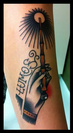 a tattoo on the leg of a woman with a hand holding an object in it