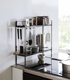 a shelf with pots, pans and utensils on it