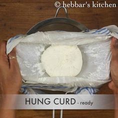 a person holding a bag over a pan with food in it and the words hung curd ready