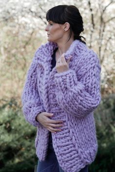 a woman is wearing a purple sweater and posing for the camera