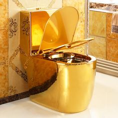 a gold toilet sitting on top of a white counter