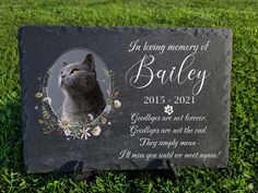 a slate memorial plaque with a cat on it's face and the words, in loving memory of bailey