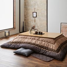 a large bed sitting on top of a hard wood floor next to a wall mounted clock