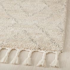 a white rug with tassels on top of it