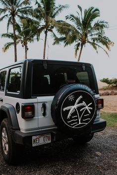 a white jeep parked in front of palm trees