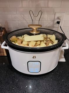 a crock pot filled with potatoes on top of a counter