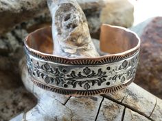 This is a beautiful Handcrafted Native American Navajo Made bracelet cuff. This is a wider cuff/bracelet and is a nice heavier weight and can be for a man or woman. It is handcrafted with Copper and has a Hand Stamped Sterling Silver 925 designed Overlay.  There is also hand stamping on the copper part of the bracelet to give it a beautiful finished design. This Item is handcrafted here in the USA and is Hallmarked by the Artist. The cuff is entirely Handcrafted which makes it a ONE OF A KIND. You get the EXACT bracelet shown. This cuff is meticulously handcrafted by C.R Little a Native American Navajo silversmith, and the quality and attention to detail is truly exceptional. With it's beautiful Hand Stamping and Southwestern design this unique bracelet would be perfect for layering or wea Southwestern Engraved Cuff Bracelet As A Gift, Southwestern Stamped Cuff Bracelet As Gift, Southwestern Stamped Cuff Bracelet For Gift, Southwestern Concho Cuff Bracelet Gift, Western Style Engraved Bracelets For Gifts, Handmade Western Sterling Silver Bracelet For Gift, Artisan Bracelet With Concho As Gift, Southwestern Stamped Bracelets As Gift, Southwestern Stamped Bracelets For Gift