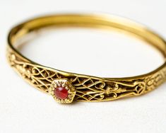 Vintage gold oval hinged bangle bracelet with floral ornate and carnelian in victorian style. Very good vintage condition (some tarnishing and discolouring, please see photos) Ready to ship, gift wrap included. DETAILS: ♥ material: gold tone metal , faux carnelian ♥ approx. size: 7 x 0.25 inch / 18 x 1 cm ♥ style: victorian ♥ unsigned ♥ from smoke-free home Please note that all items in my shop are vintage and may have signs of wear and age including scratches, tarnishing etc. Please see photos Floral Bracelet, Victorian Gold, July Birthstone, Hinged Bangle, Gold Floral, Floral Vintage, Victorian Style, Gold Bangles, Gold Tone Metal