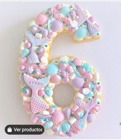 the number six is made out of cookies and decorated with seashells on it