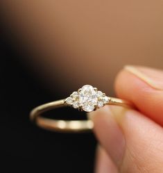 a close up of a person holding a ring with two diamonds on it's side