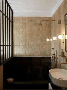 a bathroom with a sink, mirror and bathtub in the middle of the room