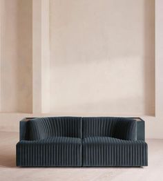 a blue couch sitting on top of a hard wood floor next to a white wall