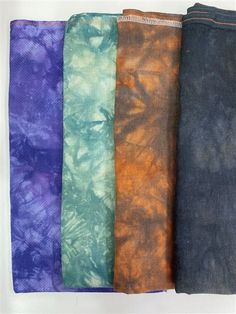 five different colors of tie - dyed fabric are lined up