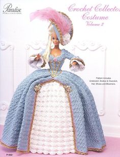 a crochet doll is wearing a blue dress and pink hat