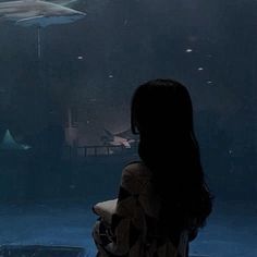 a woman standing in front of a shark tank looking at it's own sharks