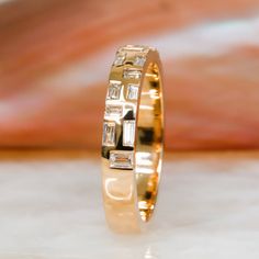 a yellow gold ring with baguets on it