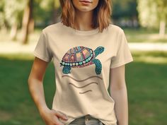 Dive into summer with this vibrant, boho-chic sea turtle t-shirt. The colorful tortoise illustration brings a playful touch to your beach wardrobe, while the comfortable fit makes it perfect for everyday wear. Enjoy the ease of a unisex design that suits everyone and celebrate ocean life with this unique graphic tee. It's an ideal gift for sea creature lovers or a special treat for yourself that adds a splash of artistry to your casual look.Product Features:Fabrication: 100% Airlume combed and r Multicolor Bohemian T-shirt For Beach, Multicolor Bohemian T-shirt For The Beach, Bohemian Multicolor T-shirt For Beach, Bohemian Graphic Print T-shirt For Beach, Tortoise Illustration, Beach Wardrobe, Sea Creature, Ocean Life, Staple Pieces