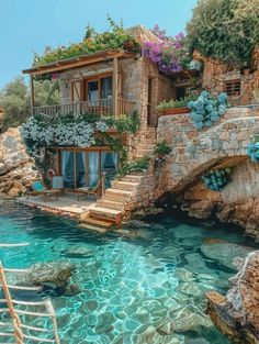 an image of a house that is on the cliff by the water with stairs going up to it