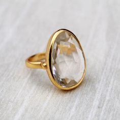 D E T A I L S - Material: 92.5 sterling silverStone: CrystalThe fit: true to US ring size Finish: smooth and Gold Plated to a high shineS H I P P I N G & P R O D U C T I O N - My current production time is 2-6 business days, which means after those days are up, your order ships! I make everything custom to order, by hand, but I promise you it's worth the wait!R U S H - M Y - O R D E R -If you're in a rush to get your pretty new pieces, please send me a message and I'll let you know just how Gold Rings With Large Stone For Anniversary, Gold Promise Ring With Large Stone, Open Ring With Large Stone For Anniversary, Anniversary Rings With Large Stone And Open Ring Design, Anniversary Ring With Large Stone And Open Setting, Anniversary Ring With Large Stone And Open Design, Classic Large Stone Promise Ring, Anniversary Open Ring With Large Stone, Classic Crystal Ring With Large Stone For Anniversary