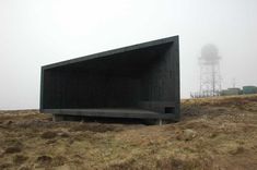 a black structure sitting on top of a dry grass field