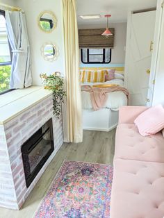 a pink couch sitting next to a fireplace in a living room filled with furniture and decor