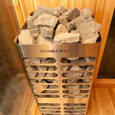 a metal basket filled with rocks on top of a wooden floor