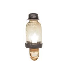 a light that is on top of a wall mounted bottle with a glass jar attached to it