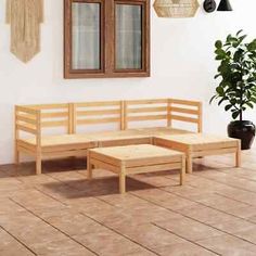 a wooden bench sitting next to a potted plant on top of a hard wood floor