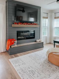 a living room filled with furniture and a flat screen tv mounted on the wall above a fire place