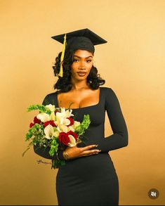 a woman wearing a graduation cap and gown holding a bouquet of flowers in her hand