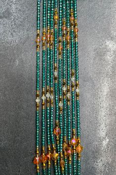 the beads are green and gold with little flowers on them, as well as other beads