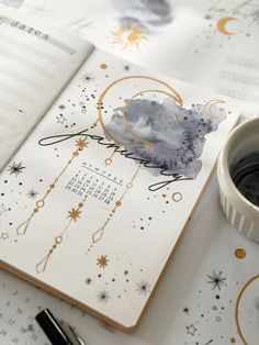 an open planner with a cup of ink next to it