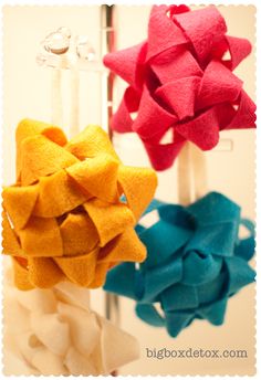 three different colored bows hanging from hooks