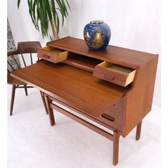 a wooden desk with a blue vase on top