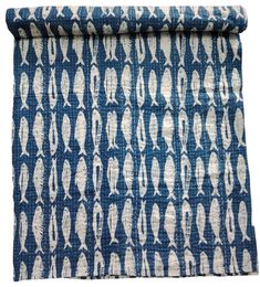 a blue and white patterned fabric with fish on the front, in an abstract pattern