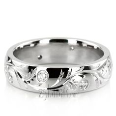 a white gold wedding ring with diamonds on the side and leaves in the middle,