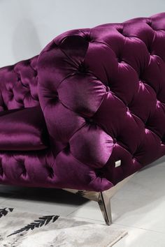 a purple chair sitting on top of a white floor next to a black and white rug