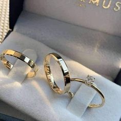 two gold wedding rings sitting in a box