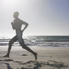 a man running on the beach near the ocean