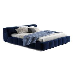 a blue bed with two pillows on top of it and a blanket over the headboard