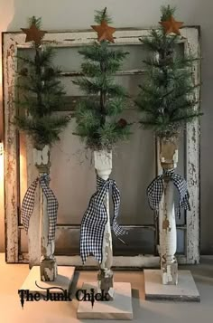 two white vases with pine trees in them