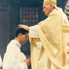 a man in a priest's outfit standing next to another man